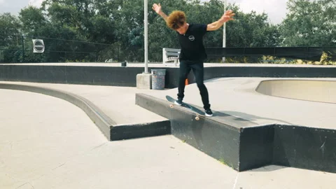 Man Does a Short Grind on Ledge At A Skatepark Video stock 168039057