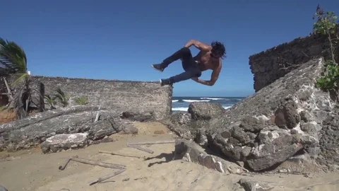 Man Does Sideflip off Ruins into Sand Stock Footage 79277393