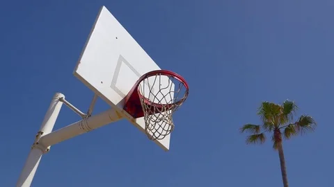 A man does a slam dunk while playing one-on-one basketball hoops on a beach cour Stock Footage