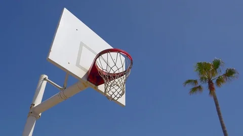 A man does a slam dunk while playing one-on-one basketball hoops on a beach cour Stock Footage
