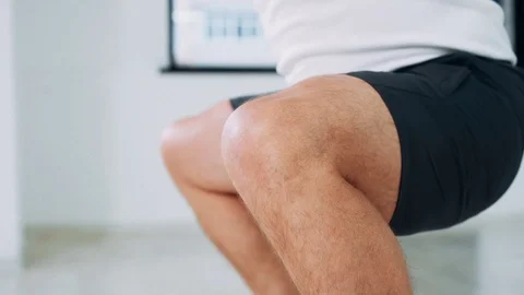 A man does a squat with a kettlebell. A man in the studio lifts weights and does Stock Footage 114164975