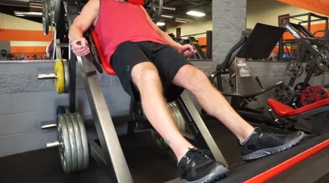 Man Does Squat Machine At Gym Vídeos de archivo 61576817