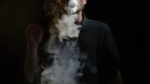 A man does tricks with vap smoke, slow motion