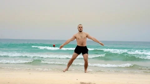 A man does a warm-up, fitness on the seashore, walking on the shore Stock Footage 262003019