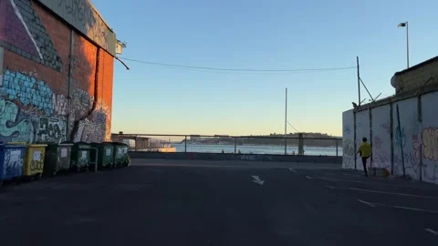 A man does a warm-up before a run. Industrial area near the water. Stock Footage 242198019