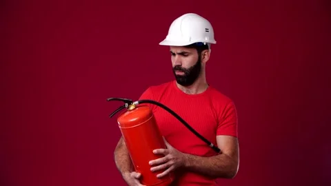 The man doesn't know what to do with the fire extinguisher and throws it away Stock Footage 165621575