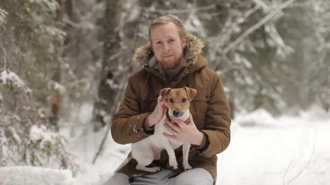 Man With a Dog Are Sitting in the Winter Forest Video stock 73655112