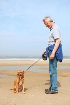 Man with dog at the beach Stock Photos