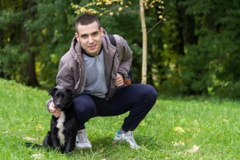 Man with a dog on the grass Stock Photos