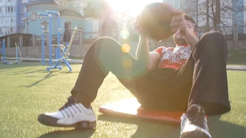 Man doing ab exercise with medicine ball - outdoor fitness Stock Footage 127033835