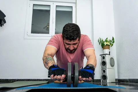 Man doing ab roller exercise for core strength Stock Photos