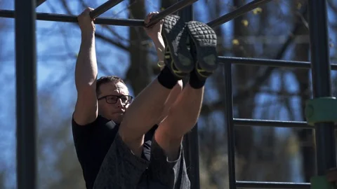 Man doing ab workout on the outdoor fittnes equipment, stock video Stock Footage 105601575