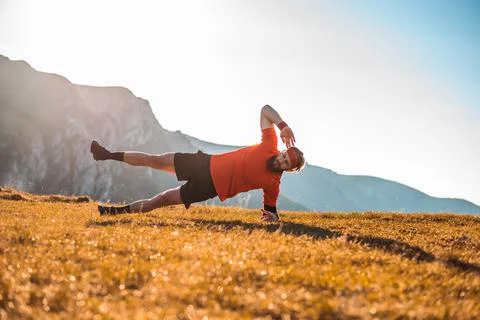 A man doing abs exercises on top of a mountain Stock Photos