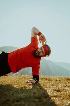 A man doing abs exercises on top of a mountain Foto stock