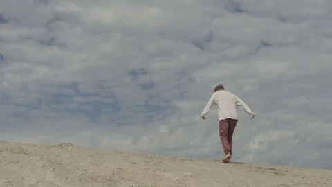 Man doing acrobatic stunt on sand 動画素材 80714389