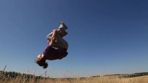 Man doing back flip in the field Stock Footage 158012235