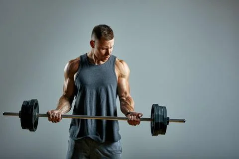 Man doing back workout, barbell row in studio over gray background. Copy space Stock Photos