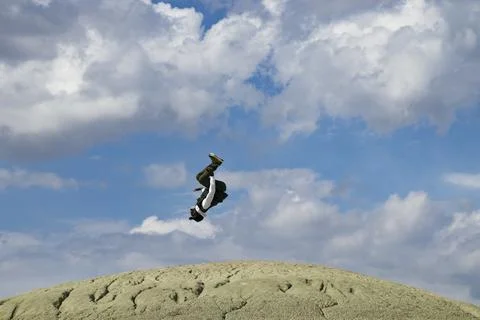 Man doing a backflip on mountain of on top of the mountain. Stock Photos