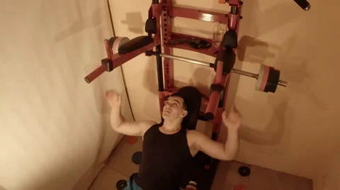 Man Doing a Bench Press With a Barbell on Swedish Wall in the Room Stock Footage 62475931