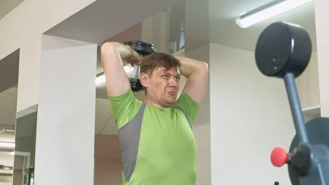 Man doing bench press with dumbbells in fitness studio Stock Footage 108071810