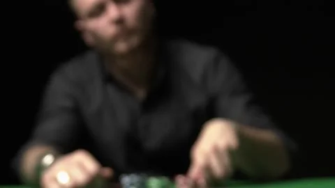 Man doing a bet, red chips scattering over green table towards Stock Footage 205210518