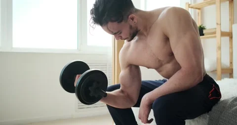 Man doing biceps exercise sitting on bed Video stock 156521131