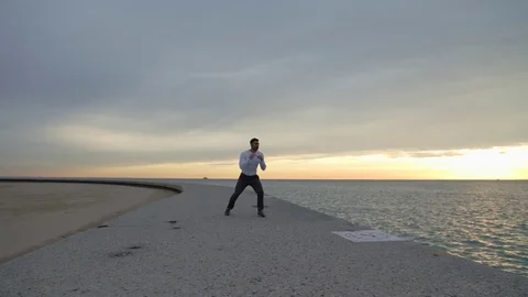 Man is doing boxing exercises on the ebankment. Athlete training outdoors Video stock 82638074