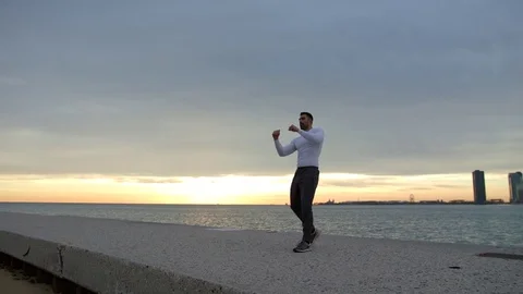 Man is doing boxing exercises on the ebankment. Athlete training outdoors Stock-Footage 82640572