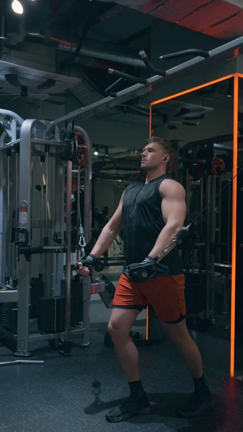 Man Doing Cable Crossover Chest Exercise in Dark Gym Vidéo 340550079