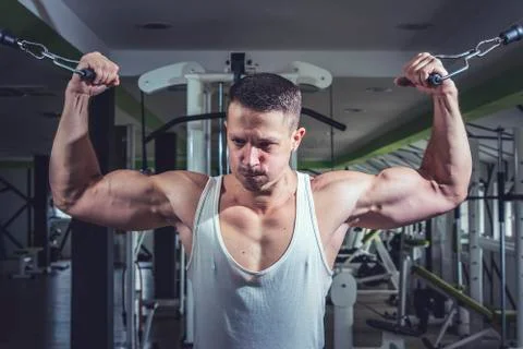 Man doing cable fly exercise in gym Stock Photos