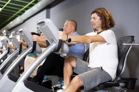 Man doing cardio training on stationary bike in gym Stock Photos