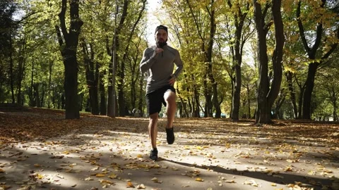 Man doing cardio warm-up in the park Stock Footage 229872385