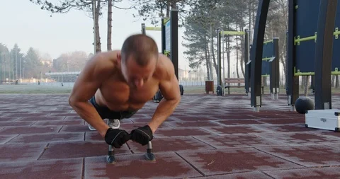 Man doing chest and triceps push ups in the park Stock Footage 121714914