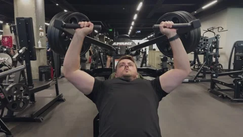 Man doing chest press exercise on a gym machine for strength training Vidéo 339599178