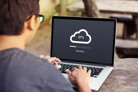Man doing cloud uploading on laptop / computer at the park / outdoor Stock Photos