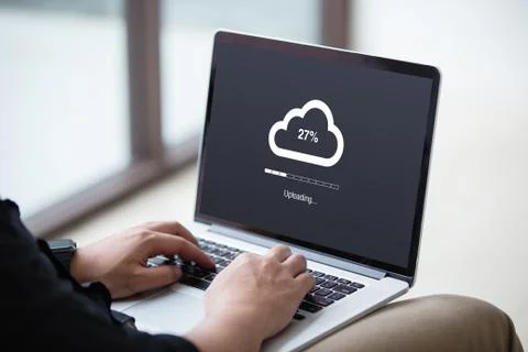 Man doing cloud uploading on laptop / computer at office Stock Photos