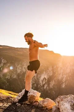 Man doing conditioning training on top of a mountain in the early morning with Stock Photos
