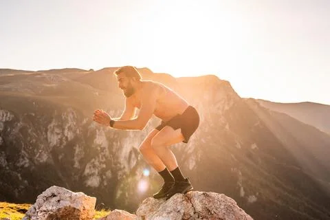 Man doing conditioning training on top of a mountain in the early morning with Stock Photos