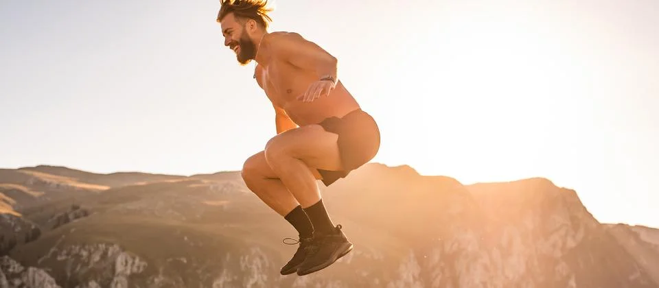 Man doing conditioning training on top of a mountain in the early morning with Stock Photos