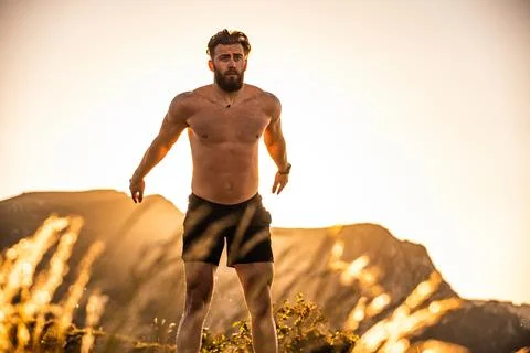 Man doing conditioning training on top of a mountain in the early morning with Stock Photos