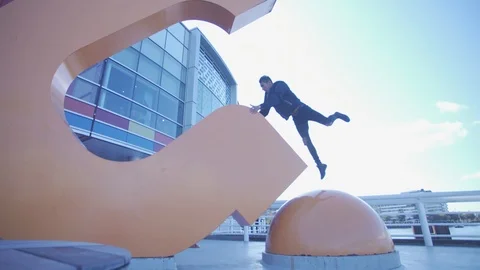 Man Doing Creative Parkour Movement on City Sculpture Vancouver Stock Footage 117649626