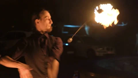 Man is doing dangerous magic trick with fire. He is showing the fire performance Stock Footage 132249289