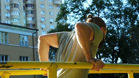 Man doing dips at outdoor workout. Athlete doing  training on parallel bars. Stock-Footage 90371652