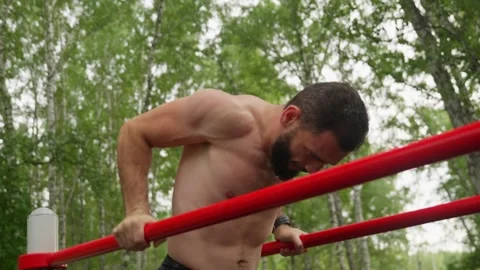 Man Doing Dips on Parallel Bars Outdoors Stock Footage 329599210