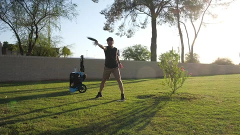 A man doing a disc golf shot from mid range Stock Footage 246826768