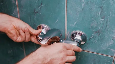 Man doing DIY plumbing repairs during a home renovation. The handyman homeowner  Stock Footage 340653916