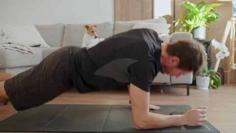 Man doing up down plank exercise on fitness mat at home Stock Footage 328043788