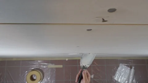 A man doing drywall plaster work on a home remodeling project Vídeos de archivo 96020528