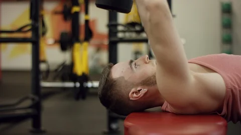 Man doing dumbbell pullovers, lying on bench, chest exercise, close-up Stock Footage 97460728