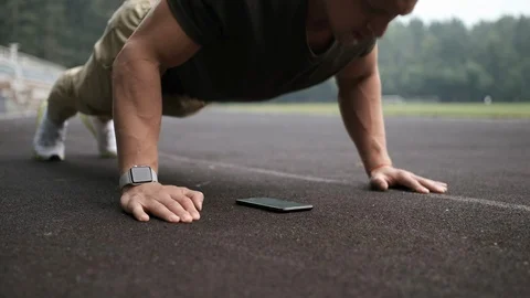 Man doing exercise and looking into smartphone on floor during training. Video stock 113061466